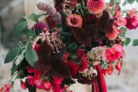 a lush and dimensional wedding bouquet in burgundy, red, pink blooms and greenery