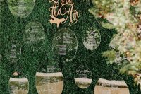 a modern fall wedding seating chart of a boxwood wall, bright and blush florals and acrylic circles is awesome