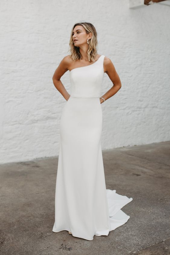a modern one shoulder A line wedding dress with an embellished edge and waist plus a train is a lovely idea for a modern and glam bride