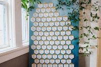 a modern seating chart with gilded hexagons and lush greenery for decor will fit not only a fall wedding