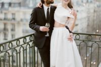 a modern two piece elopement ensemble with a crop top with appliques and a high low A-line skirt with a train