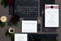a moody invitation suite with black envelopes and moody floral lining plus white invites