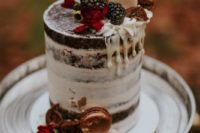 a naked chocolate fall wedding cake topped with blackberries, metallic macarons, blooms and a delicate monogram topper