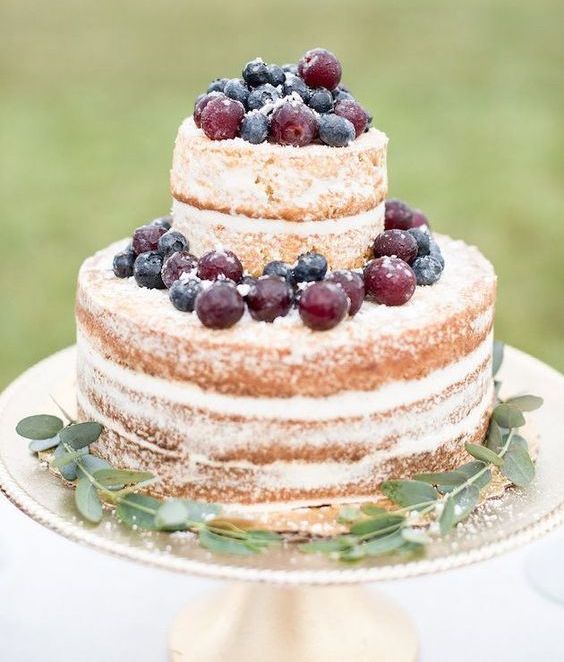 a naked wedding cake topped with fresh berries and foliage is a simple and laconic fall idea