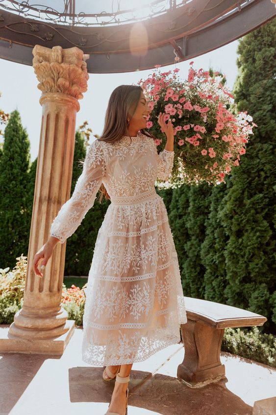 a nude and white lace tea length wedding dress with a high neckline, long sleeves, nude wedding shoes