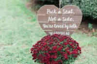 a pallet heart sign, a wooden basket with burgundy blooms on a crate for decorating an outdoor fall wedding space