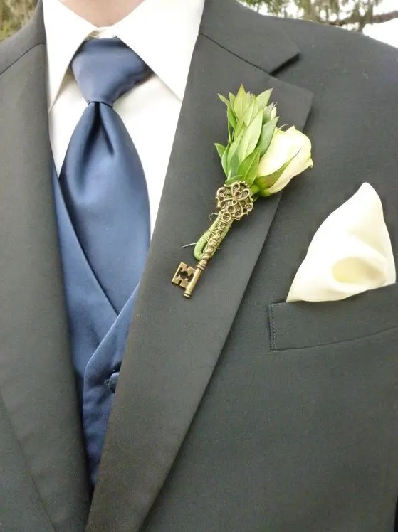 a pretty wedding boutonniere with a white rose, leaves and a vintage key is a lovely accessory for a groom or a groomsman