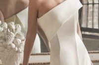 a refined modern A-line wedding dress with a one shoulder bodice, catchy lines and a front slit for a sophisticated modern bride