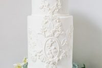 a refined white wedding cake with sugar patterns and blooms is perfect for a vintage wedding