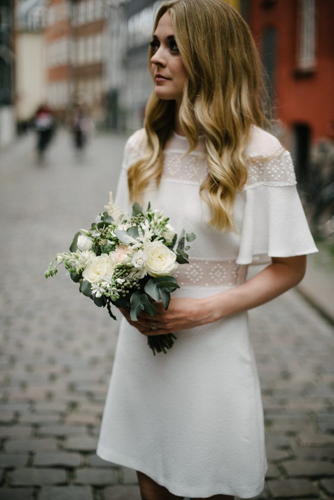 a retro-inspired plain wedding dress with sheer inserts, short sleeves and a high neckline for a modest and chic look
