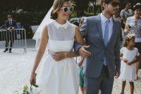 a retro-loving bride wearing an A-line wedding dress with an illusion neckline, a collar, a pleated skirt and peep toe shoes