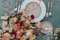 a romantic fall wedding centerpiece of muted color blooms and some branches with berries is a beautiful idea of an arrangement