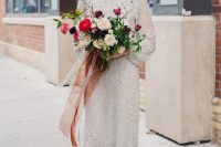 a shiny and boldly embellished midi silver wedding dress with a high neckline, long sleeves and fluffy black shoes