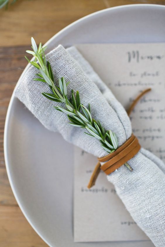 a simple leather cord napkin ring and a herb twig are great for a nature inspired and laid back wedding