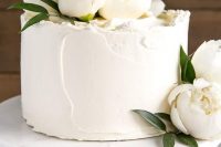 a small textural white wedding cake topped with white peonies for a chic look, texture brings it all