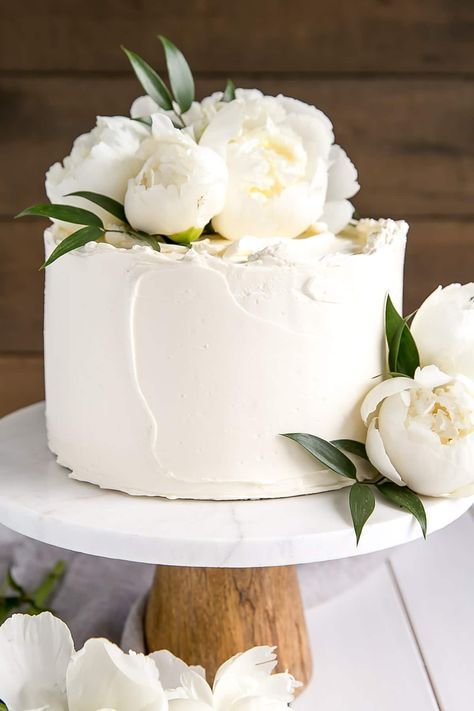 a small textural white wedding cake topped with white peonies for a chic look, texture brings it all