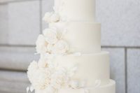 a sophisticated white wedding cake with breathtaking white sugar blooms and leaves is a beautiful idea