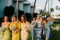 a super colorful and mismatching bridal party with yellow and blue bridesmaid dresses including a black thick strap striped one