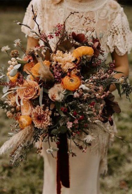 a super textural and dimensional fall wedding bouquet of yellow, pink, deep purple and burgundy blooms, twigs, greneeyr and grasses is amazing