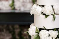 a trio of minimalist plain wedding cakes served with white peonies is an elegant modern wedding idea
