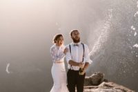 a two piece wedding dress of lace with a crop top with long sleeves and a mermaid skirt with train