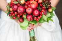 a unique wedding bouquet of fresh red and burgundy fruits and foliage is amazing for the fall