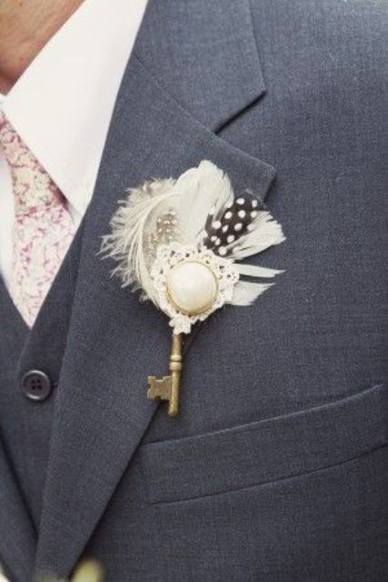 a vintage groom's outfit with a vintage key, a brooch with lace and some feathers is a lovely accessory for a vintage wedding
