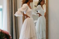 a vintage-inspired and boho bridal look with a lace A-line wedding dress with a square neckline, puff and bell sleeves, a tiered ruffle skirt and a train