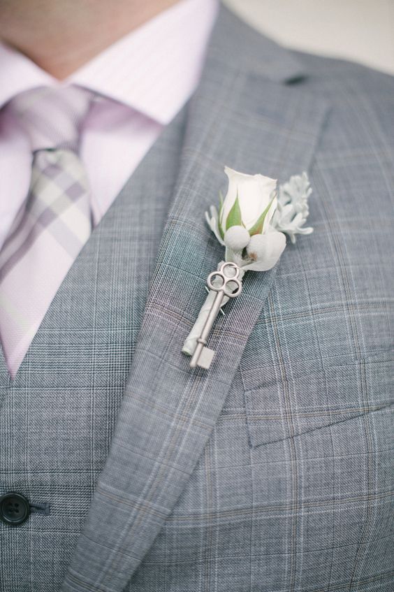 a vintage wedding boutonniere of a white rose, pale leaves, a vintage key and some berries is awesome for a vintage wedding