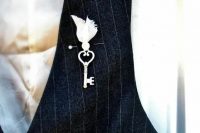 a whimsy boutonniere of a vintage key and a bead in a fabric cover looks vintage and fairy-tale-like at the same time