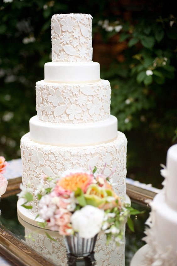 a white floral pattern wedding cake with plain tiers is a real masterpiece for a garden wedding