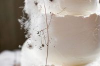 a white textural wedding cake with a raw edge and some dried blooms is a fantastic idea for a modern wedding