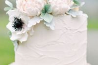 a white textural wedding cake with white and blush sugar blooms and leaves is a timeless idea for any wedding