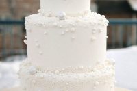 a white wedding cake with sugar pearls attached is ideal for a winter wonderland wedding