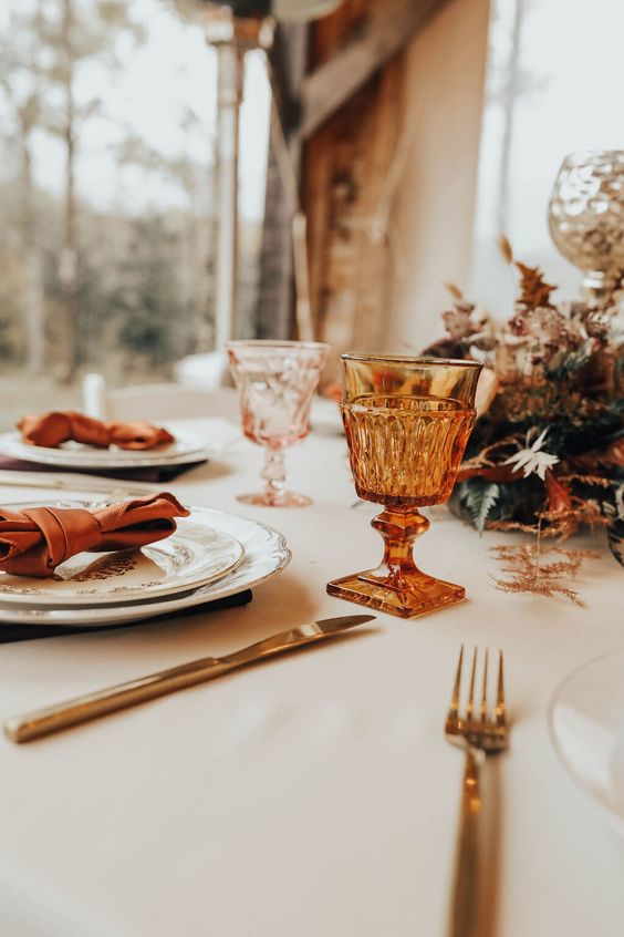 amber and pink goblets, gold cutlery, copper napkins and bright dried leaves are great for a fall wedding