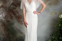an airy and flowing wedding dress with a deep V neckline, flowy short sleeves, some matching beading for an art deco wedding