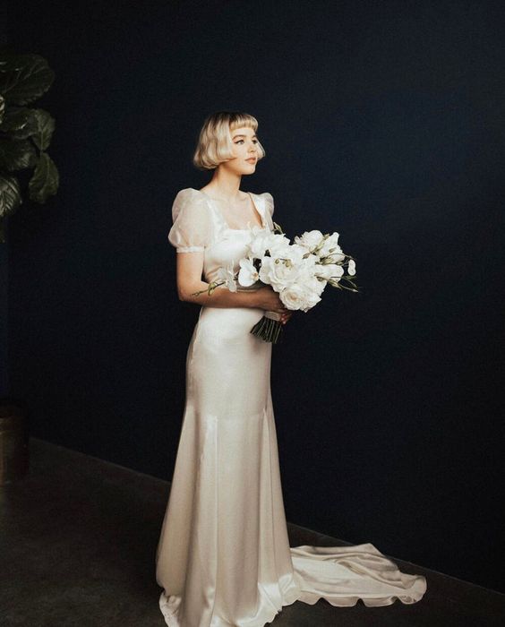an elegant 20s inspired silk wedding dress with a square neckline, short puff sleeves, a train is a gorgeous idea