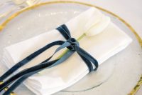 an elegant navy velvet napkin ring with a white tulip is a sophisticated and chic idea for many types of weddings