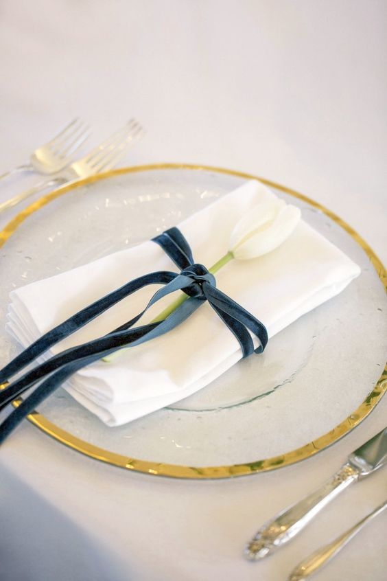 an elegant navy velvet napkin ring with a white tulip is a sophisticated and chic idea for many types of weddings
