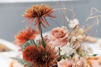 an ethereal wedding centerpiece with white, blush and rust-colored blooms and dried herbs for a fall wedding