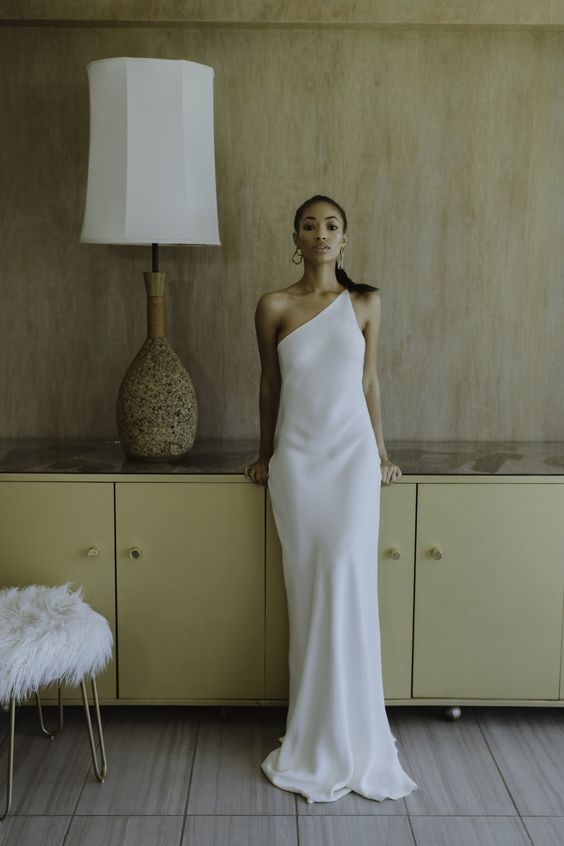 an ultra-minimalist plain one shoulder wedding dress with a small train is a stylish idea for a minimalist bride