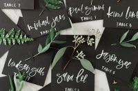 black cards with names and fresh greenery attached are very natural escort cards for a fall or other wedding