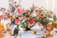 copper cutlery, amber goblets and a lush floral and berry centerpiece make the tablescape very chic and refined