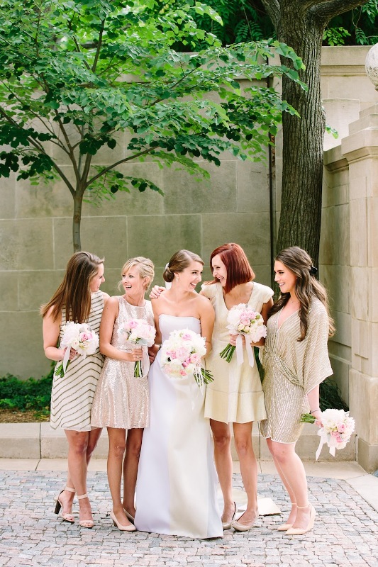 lovely glam mismatching bridesmaid dresses including a sleeveless mini striped one, a silver sequin mini dress, a neutral A-line dress and an embellished striped dress