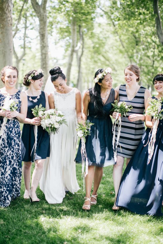 mismatching nautical bridesmaid dresses in navy and white with a fitting knee dress with no sleeves and a deep neckline