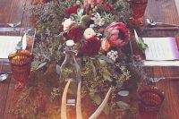 moss, eucalyptus, antlers and bold florals for a woodland-inspired table runner, candles, clear chargers and dip-dye menus