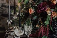 a beautiful decadent Halloween wedding table with a printed runner, fuchsia napkins and a lush centerpiece with matching blooms, black candles