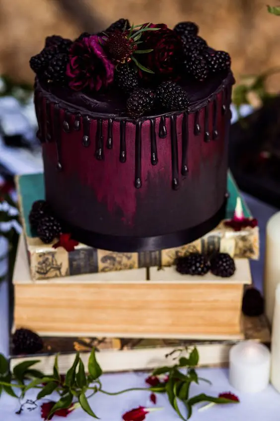 a beautiful purple ombre wedding cake with chocolate drip, fresh berries and blooms is stylish for Halloween