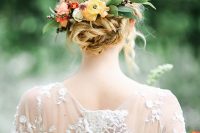 a beautiful twisted updo with bold blooms and greenery plus some blooming branches tucked in for a fall wedding