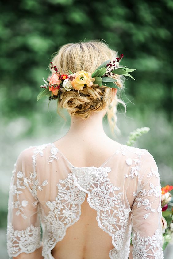 a beautiful twisted updo with bold blooms and greenery plus some blooming branches tucked in for a fall wedding